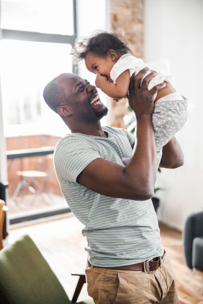 man lifting cute baby up in the air